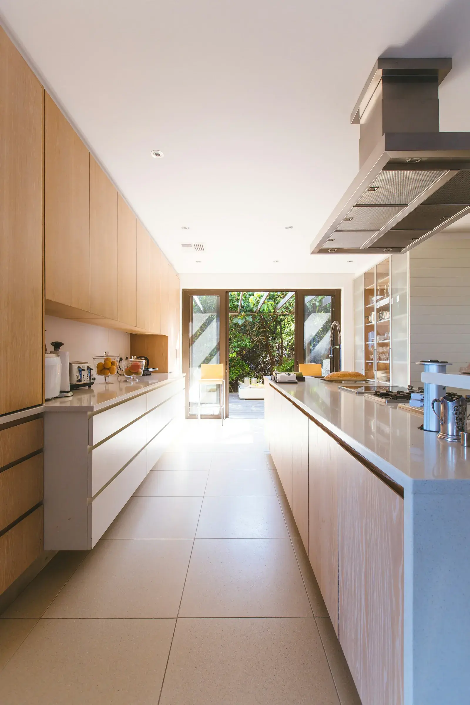 Cuina residencial amb mobiliari de fusta, taulell i llum natural